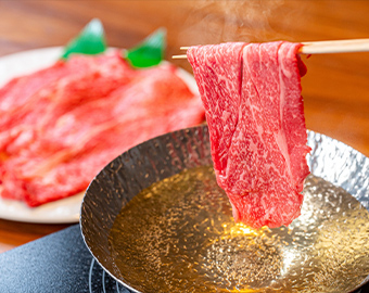 箸で霜降り和牛を出汁鍋にくぐらせる写真